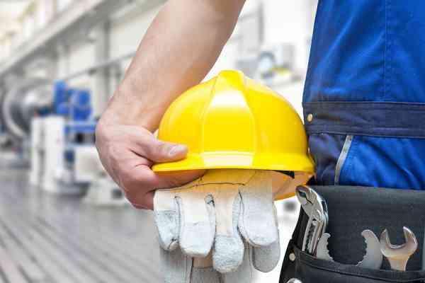 Gelber Arbeitshelm und Handschuhe