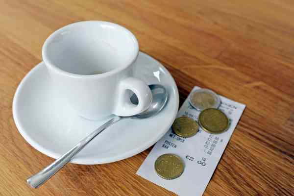 Kaffeetasse mit Rechnung und Münzen